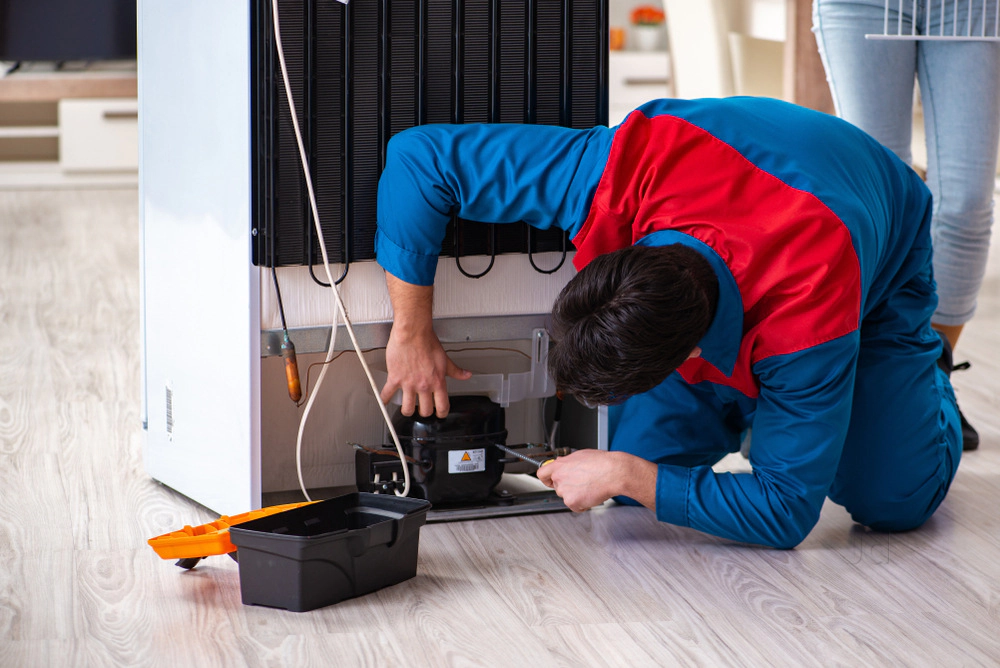 Ice World Solutions technician repairing a refrigerator